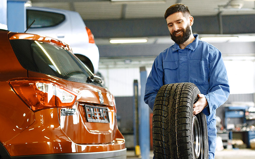Mechanic Carrying a Wheel